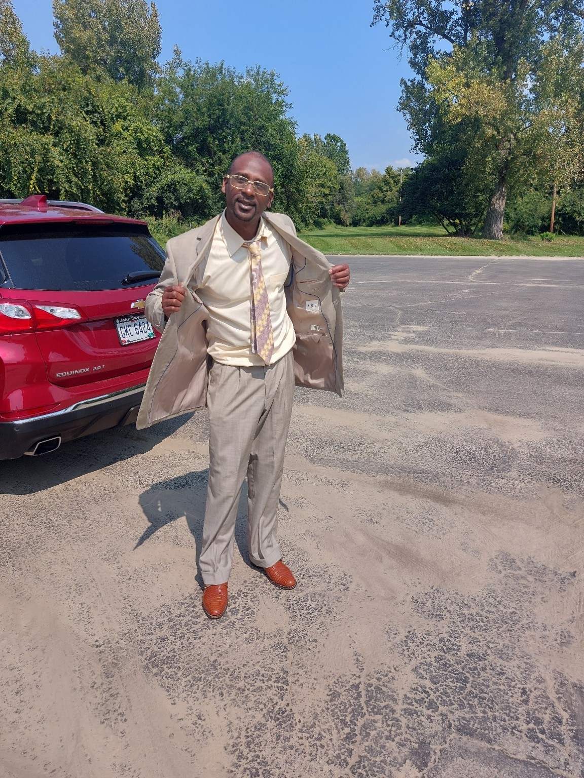 Romie The Writer in a tan suit